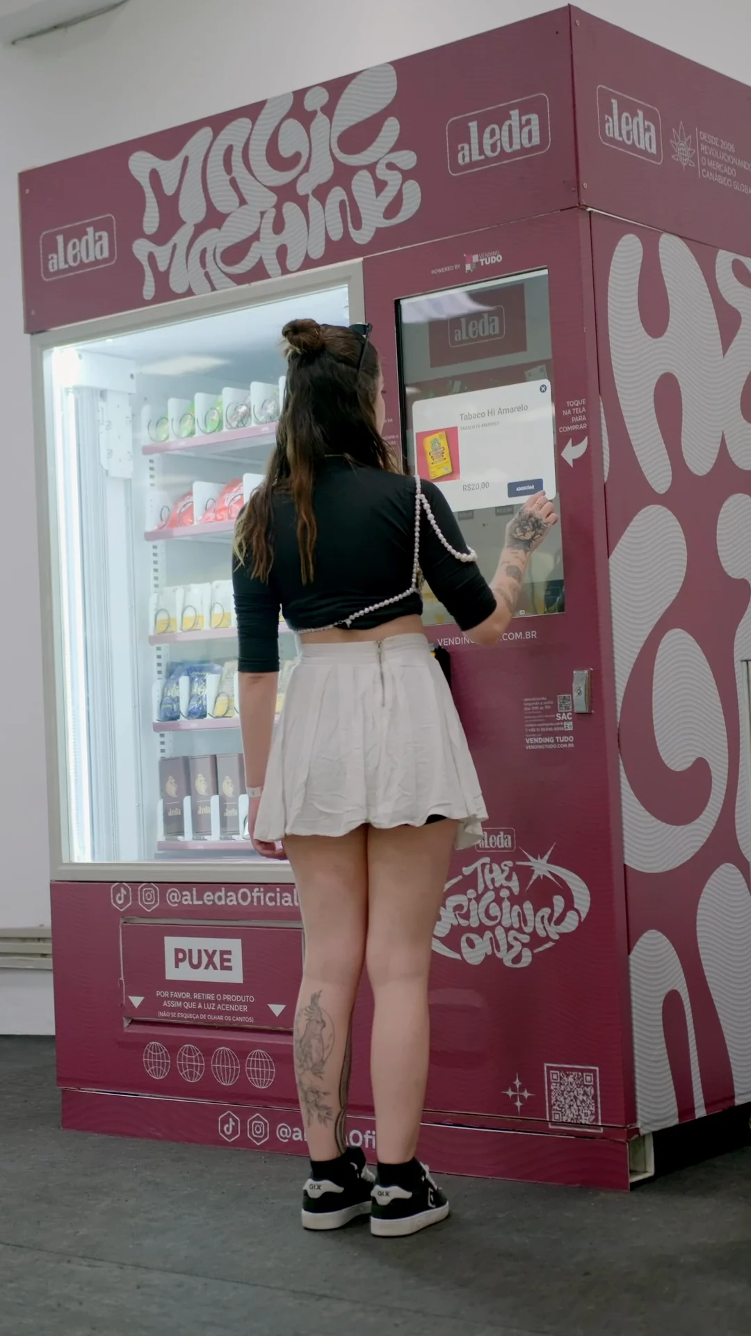 Visitante comprando na Magic Machine, a vending machine rosa da aLeda, fora do estande na Expocannabis 2024