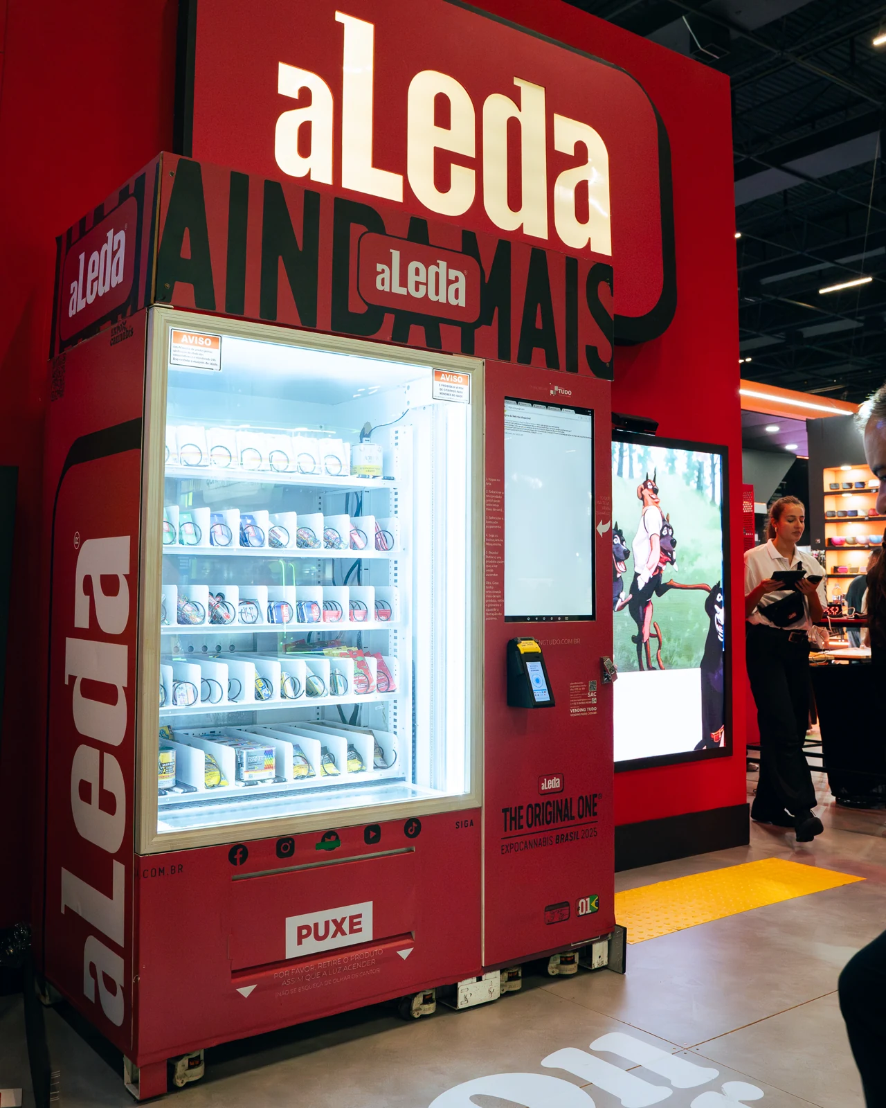 Vending machine vermelha da aLeda, com vitrine iluminada de produtos, na Expocannabis 2025