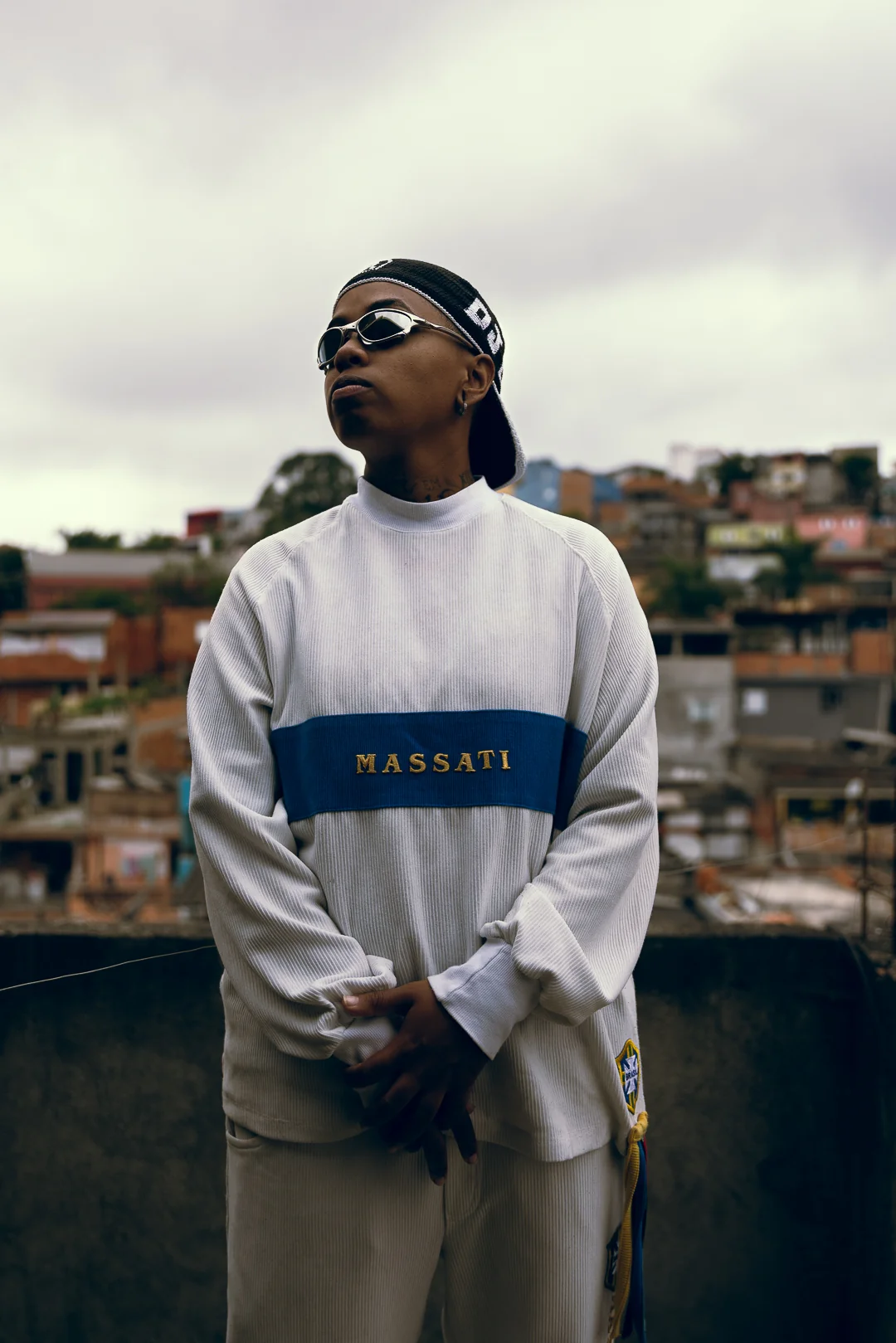 DJ Lorrany em uma laje, com o bairro ao fundo