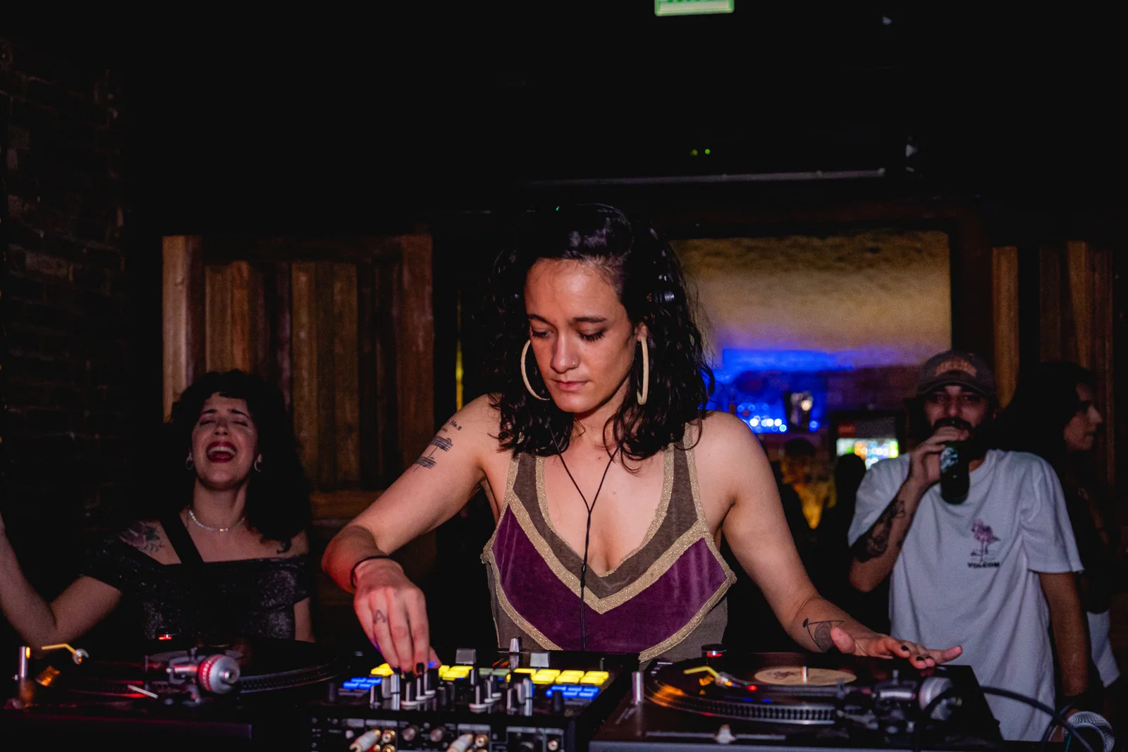 A cabine cheia na noite do centenário, com as DJs tocando e o público em volta