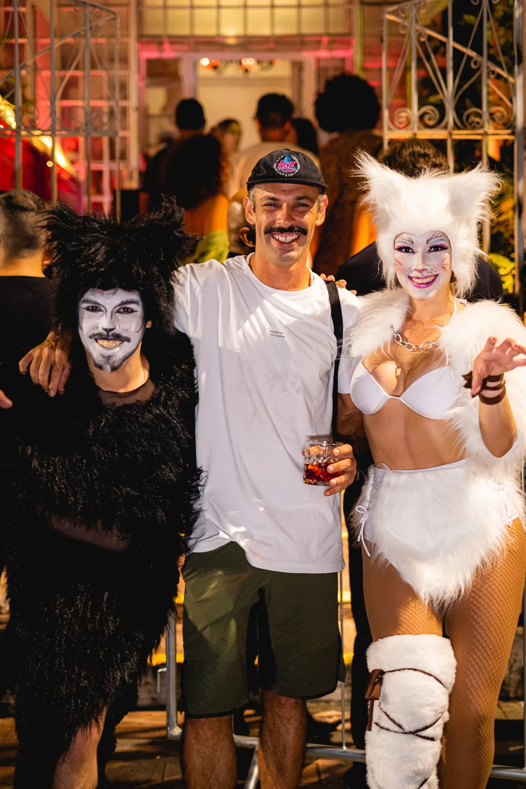 Convidados posando com o elenco do musical na rua, em frente à MEOW