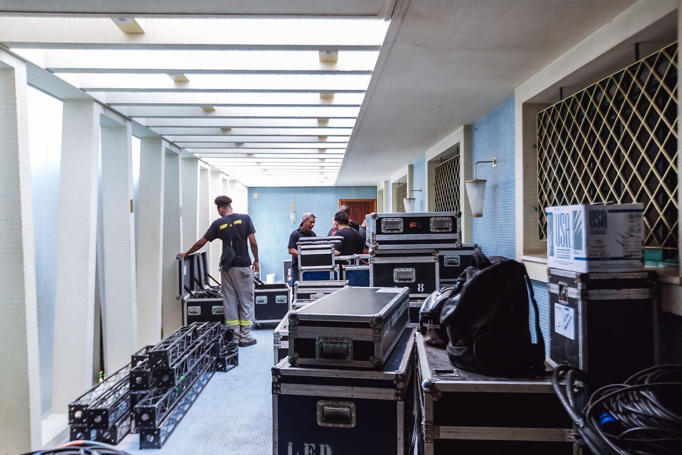 Corredor de serviço tomado por road cases de equipamento
