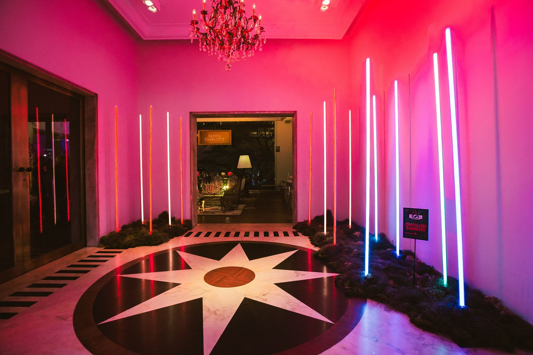 Corredor iluminado em rosa com bastões de neon
