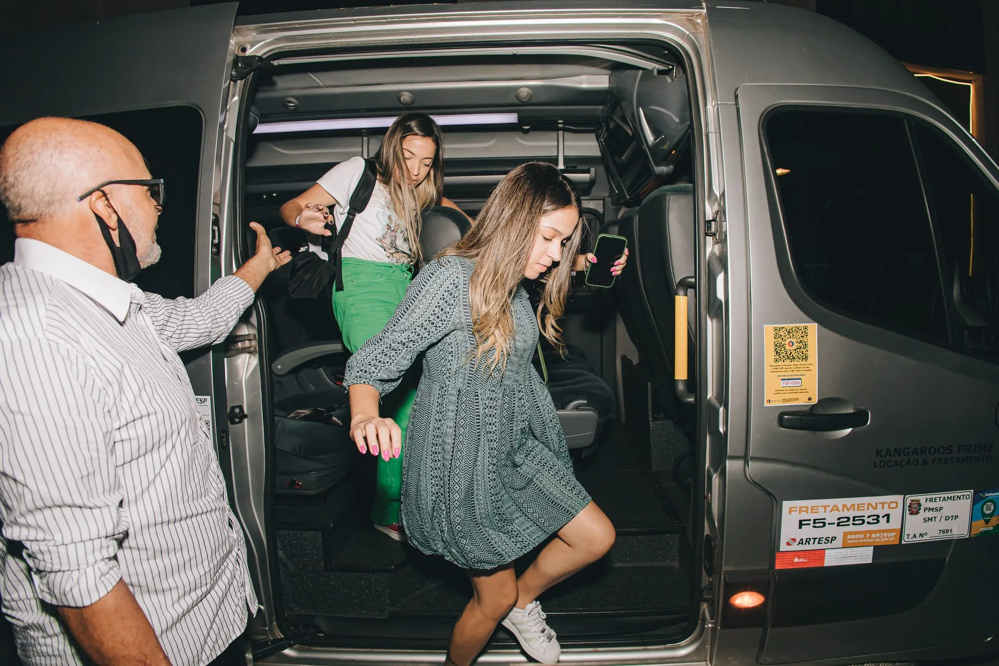 Convidados desembarcando da van no local secreto, à noite