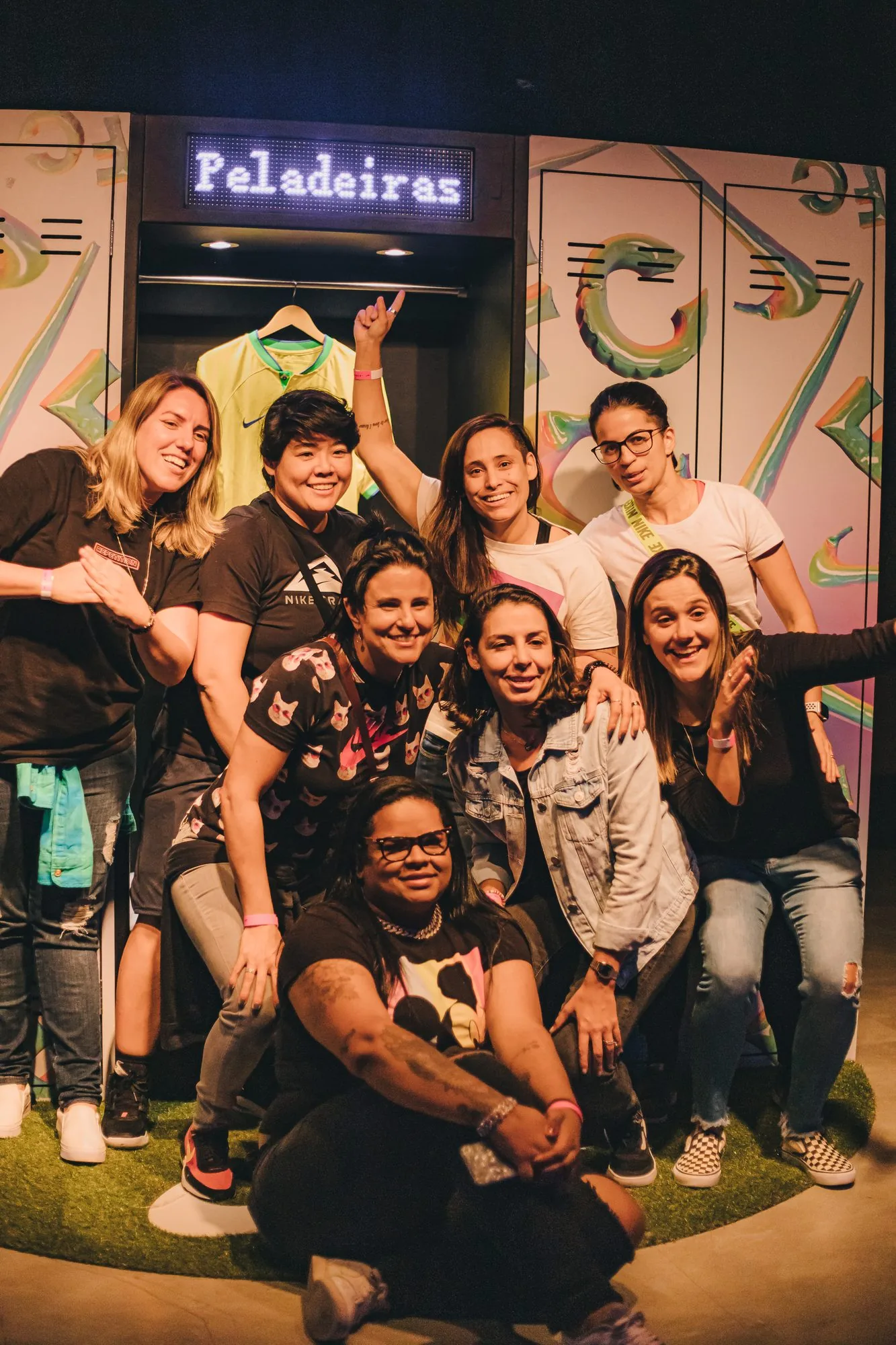 Grupo de jogadoras posando no armário com o letreiro Peladeiras