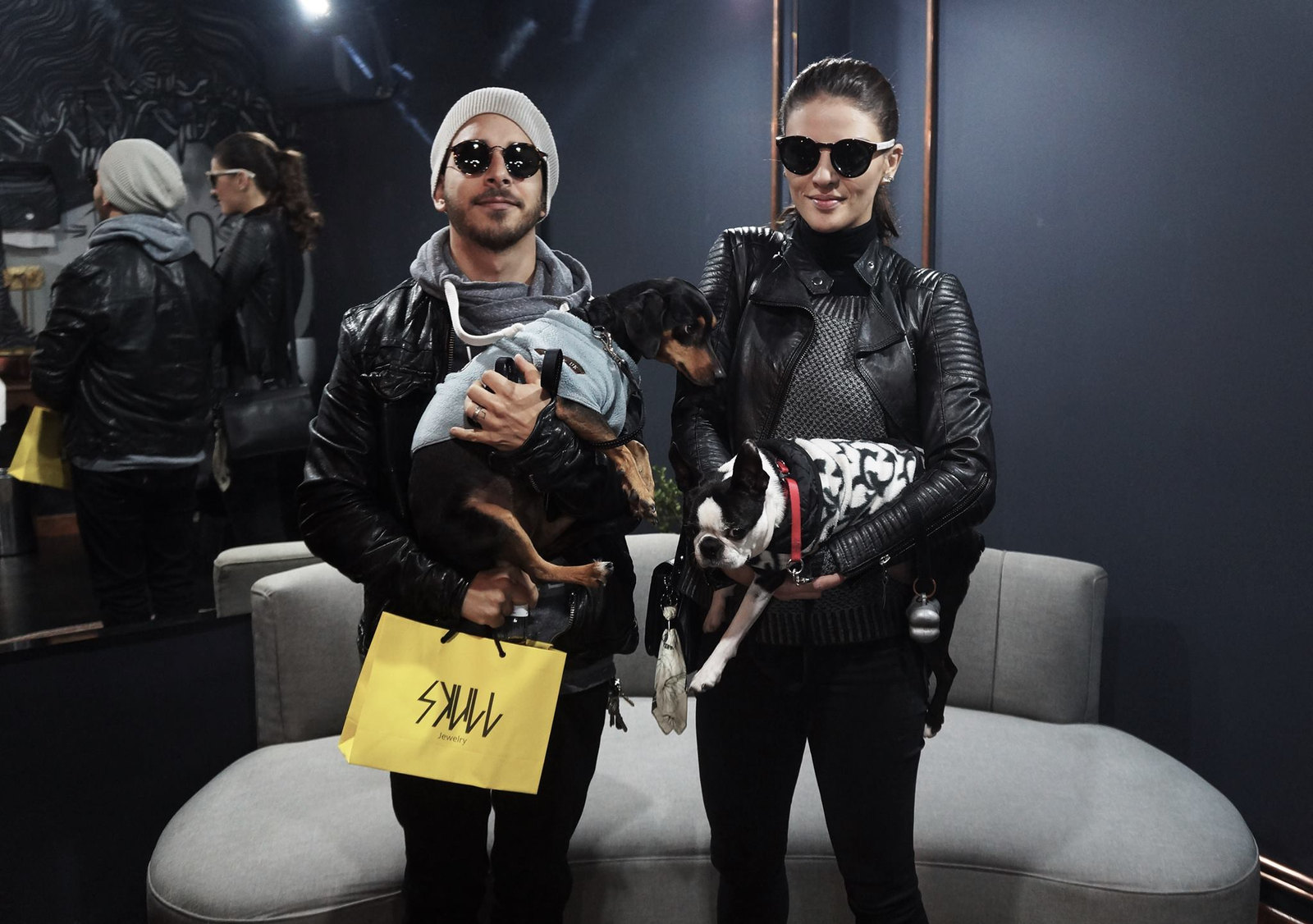 Casal com cachorros e a sacola da SKULL no sofá da loja